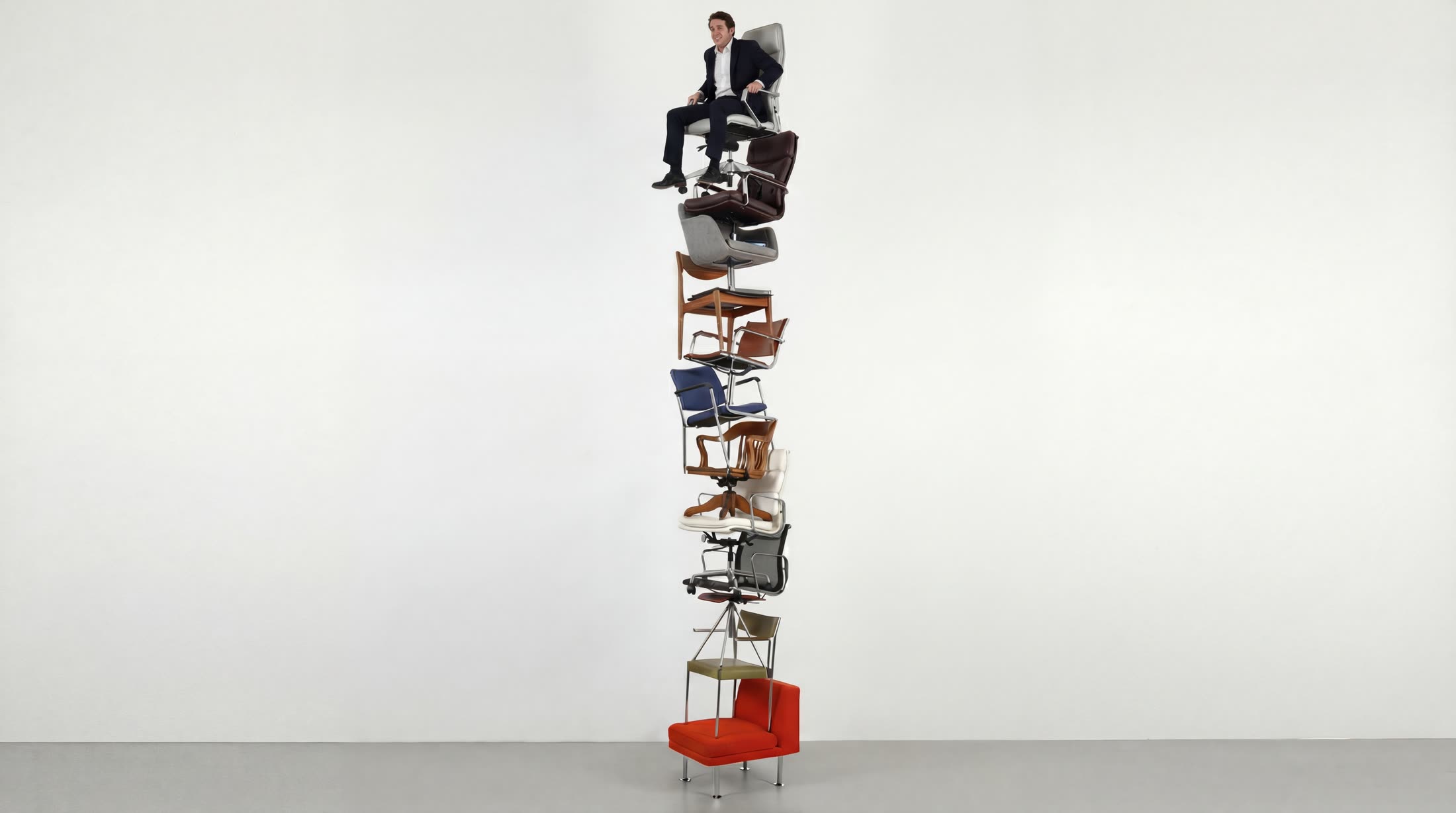 The identical chair tower, now with a smiling man in a dark suit generated in, sitting on the top chair with his legs dangling.